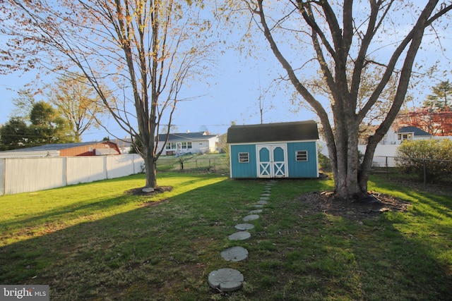 view of yard with a fenced backyard, an outbuilding, and a shed