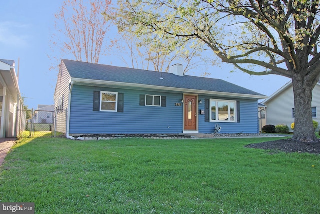 ranch-style home featuring fence and a front lawn