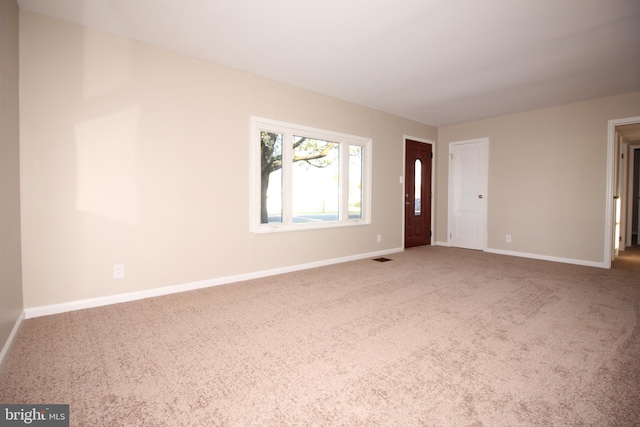 unfurnished living room featuring carpet floors and baseboards