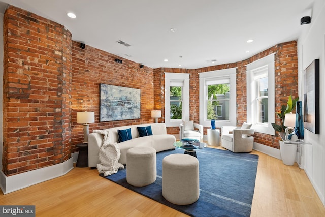 living area featuring visible vents, recessed lighting, light wood finished floors, and brick wall