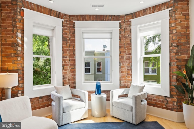sitting room featuring recessed lighting, brick wall, visible vents, and wood finished floors