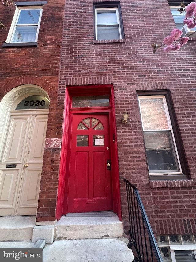 view of exterior entry featuring brick siding