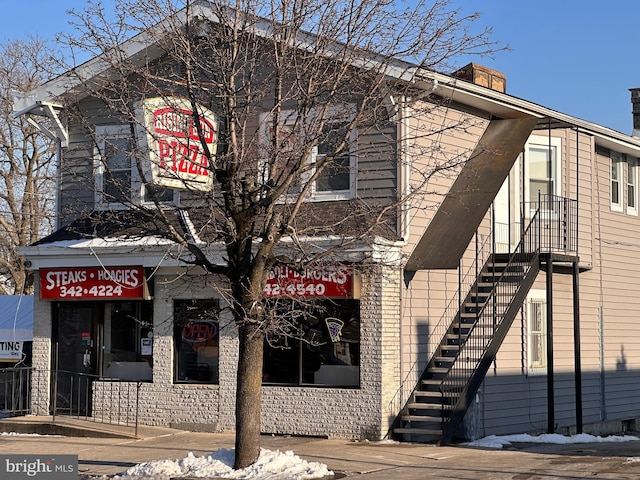 view of front of house with stairway and a chimney