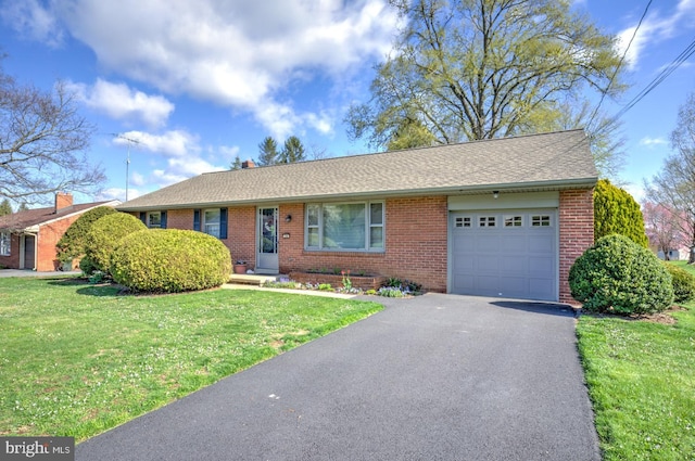 ranch-style home with a garage, brick siding, a front lawn, and driveway
