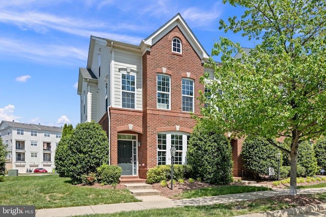 view of front of house with brick siding and a front lawn