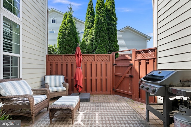 view of patio with a gate, fence, and area for grilling