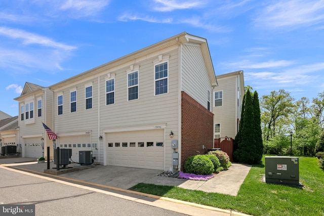 view of front of property featuring a garage, central AC unit, and driveway