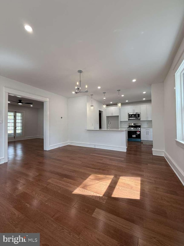 16 E Parkway Ave, Chester, PA 19013 - unfurnished living room featuring baseboards, a sink, dark wood-type flooring, and recessed lighting