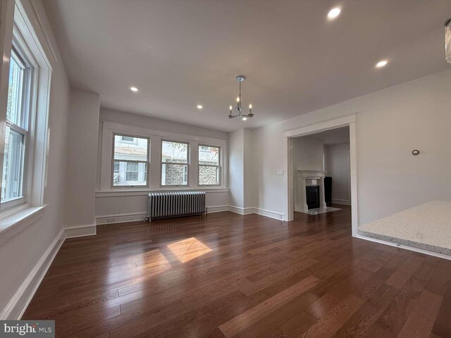 16 E Parkway Ave, Chester, PA 19013 - interior space featuring baseboards, dark wood finished floors, an inviting chandelier, and radiator