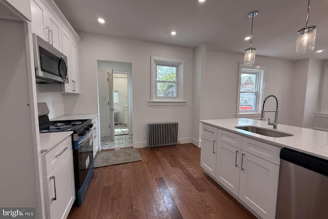 16 E Parkway Ave, Chester, PA 19013 - kitchen featuring radiator, dark wood-style floors, white cabinetry, a sink, and appliances with stainless steel finishes