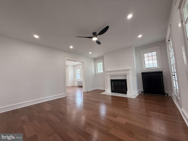 16 E Parkway Ave, Chester, PA 19013 - unfurnished living room with plenty of natural light, ceiling fan, a fireplace, and dark wood-type flooring