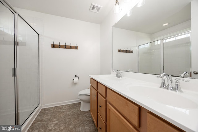 full bathroom with visible vents, a sink, a tile shower, and toilet