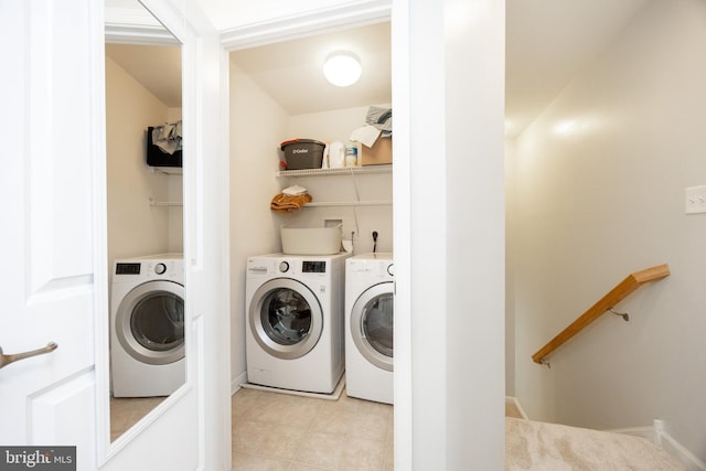 laundry room featuring washer and dryer, light tile patterned floors, laundry area, and baseboards