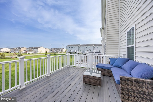 wooden deck with a lawn, outdoor lounge area, and a residential view