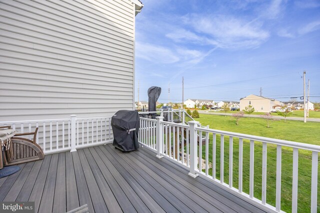 deck with area for grilling, a lawn, and a residential view