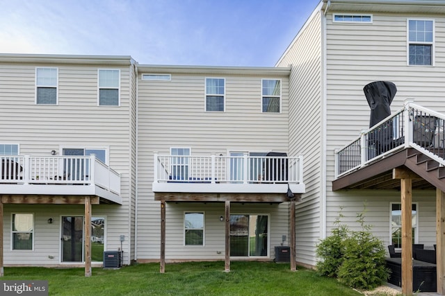 back of house featuring central AC unit and a yard