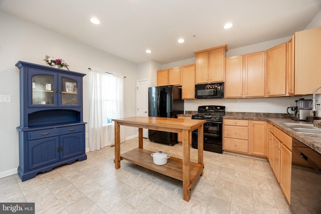 kitchen with a sink, light brown cabinetry, and black appliances