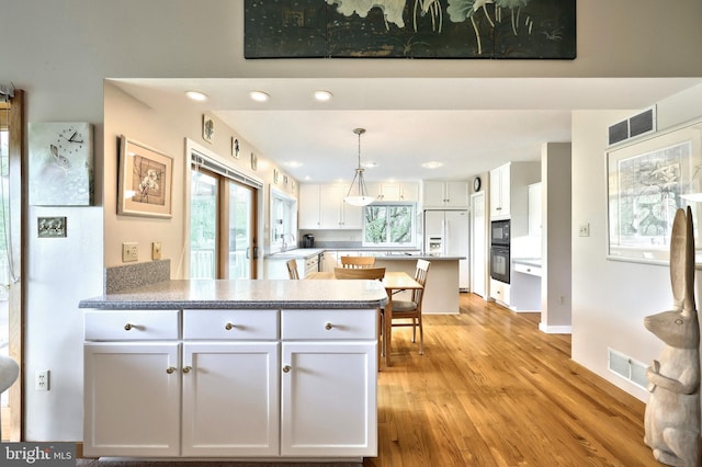 6 Pond Ridge Ln, Hanover, PA 17331 - kitchen featuring a peninsula, white fridge with ice dispenser, light wood-type flooring, white cabinets, and black microwave