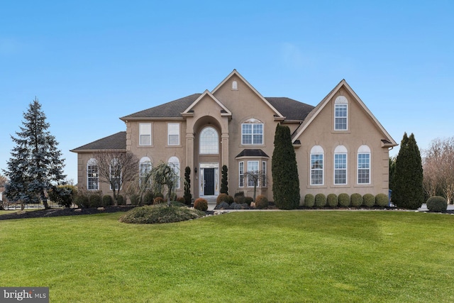view of front facade with a front yard and stucco siding
