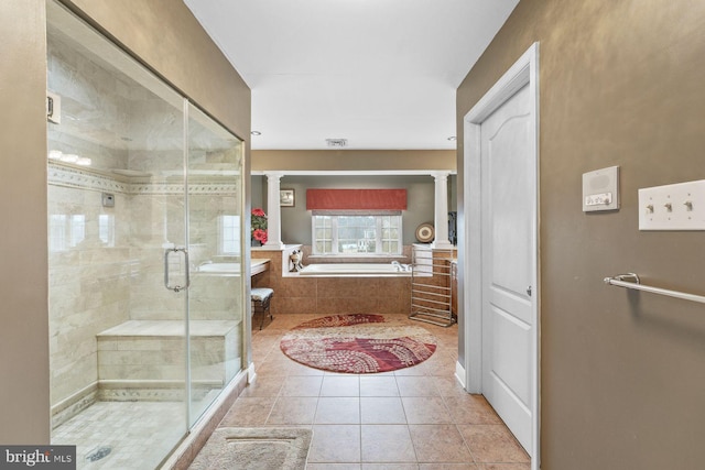 bathroom with decorative columns, a bath, visible vents, a shower stall, and tile patterned floors