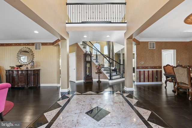 entryway with stairs, wallpapered walls, visible vents, and baseboards