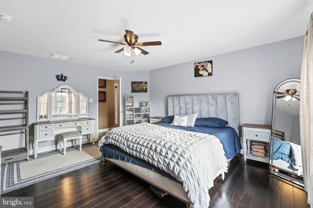 bedroom featuring baseboards, a ceiling fan, wood finished floors, and visible vents