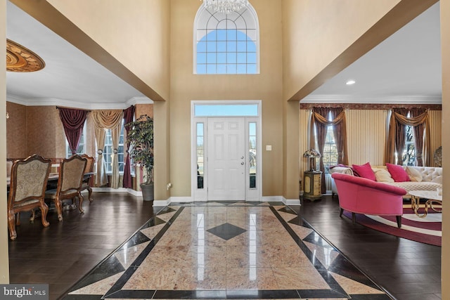 entrance foyer with crown molding, baseboards, and a wealth of natural light