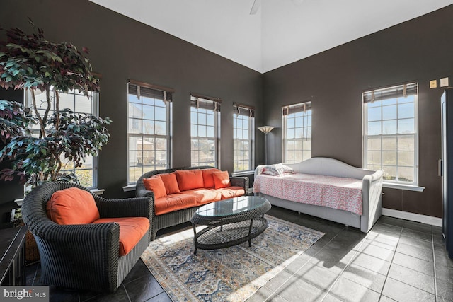 bedroom with baseboards, multiple windows, and a towering ceiling
