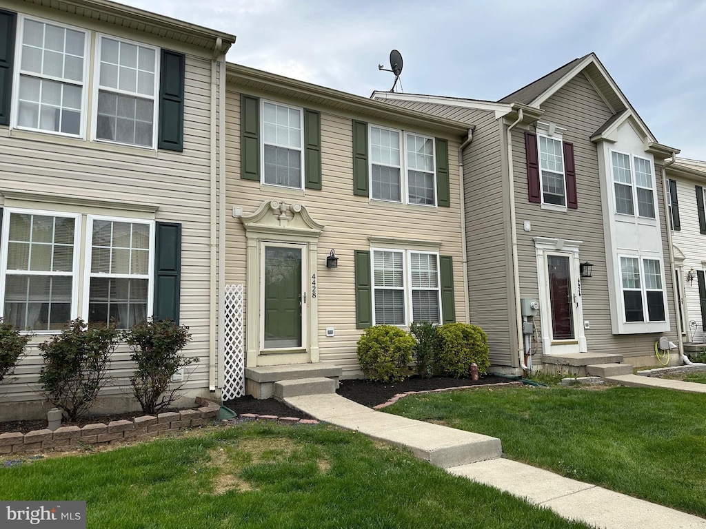view of property featuring entry steps and a front yard