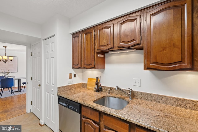 1077 30th St NW Unit 612, Washington, DC 20007 - kitchen featuring stainless steel dishwasher, a sink, light stone counters, a chandelier, and light tile patterned floors