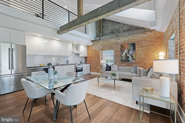 515 N Washington St Unit 404, Alexandria, VA 22314 - dining space with high vaulted ceiling, dark wood-style floors, and brick wall