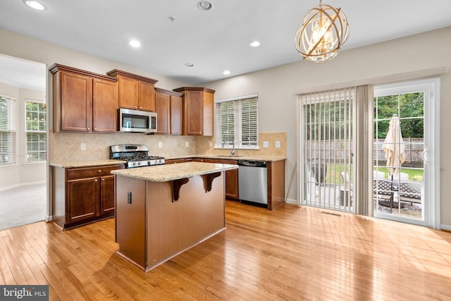 17202 Madrillon Way, Accokeek, MD 20607 - kitchen featuring stainless steel appliances, light wood-style flooring, a kitchen breakfast bar, a center island, and tasteful backsplash