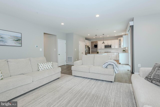 7928 Meridian Dr, Pasadena, MD 21122 - living area with light wood-style floors and recessed lighting