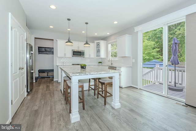7928 Meridian Dr, Pasadena, MD 21122 - kitchen featuring stainless steel appliances, a center island, tasteful backsplash, white cabinetry, and recessed lighting