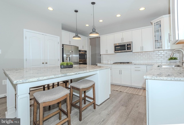 7928 Meridian Dr, Pasadena, MD 21122 - kitchen with stainless steel appliances, a sink, light wood finished floors, a center island, and recessed lighting