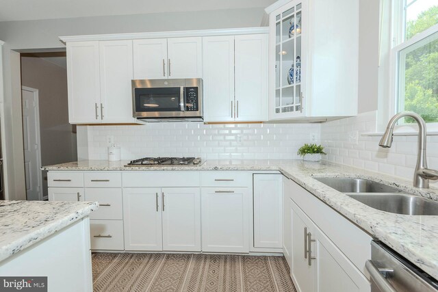7928 Meridian Dr, Pasadena, MD 21122 - kitchen featuring stainless steel appliances, a sink, white cabinetry, backsplash, and light stone countertops