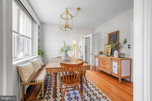 dining area featuring light wood finished floors and a notable chandelier