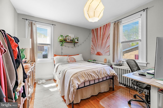 bedroom featuring wood finished floors and radiator heating unit