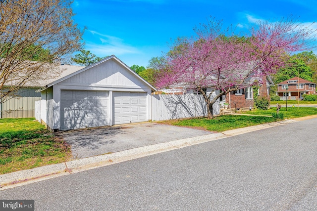 view of front of house with a detached garage and a front yard