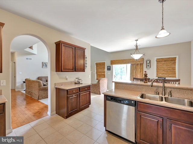 kitchen featuring a sink, arched walkways, stainless steel dishwasher, and light countertops