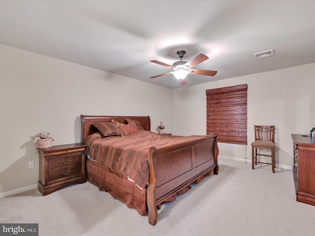 bedroom featuring visible vents, baseboards, ceiling fan, and light carpet