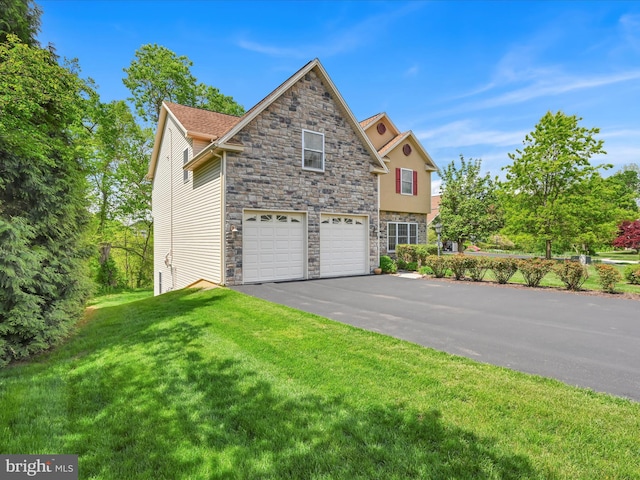 traditional-style house featuring an attached garage, driveway, stone siding, and a front lawn