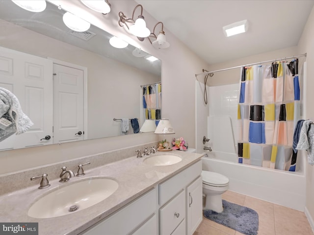 full bath with a sink, tile patterned flooring, toilet, and double vanity