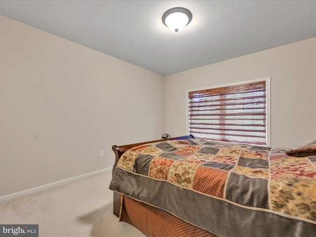 bedroom with baseboards and carpet