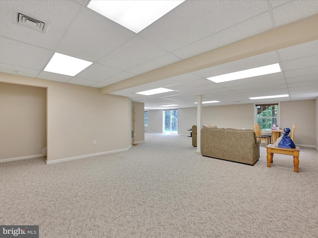 below grade area with baseboards, carpet flooring, a drop ceiling, and visible vents