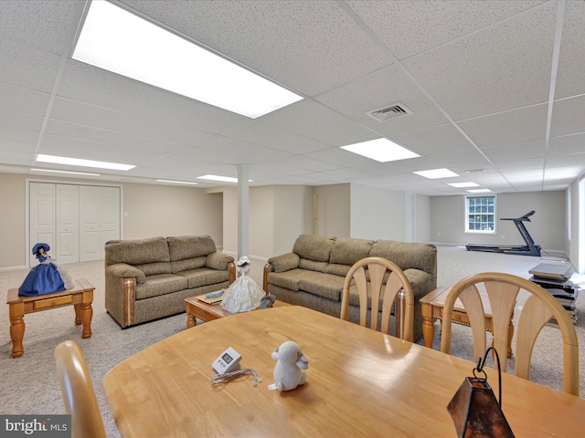 carpeted dining area with visible vents and a paneled ceiling