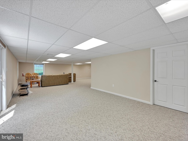 below grade area with baseboards, carpet, and a drop ceiling