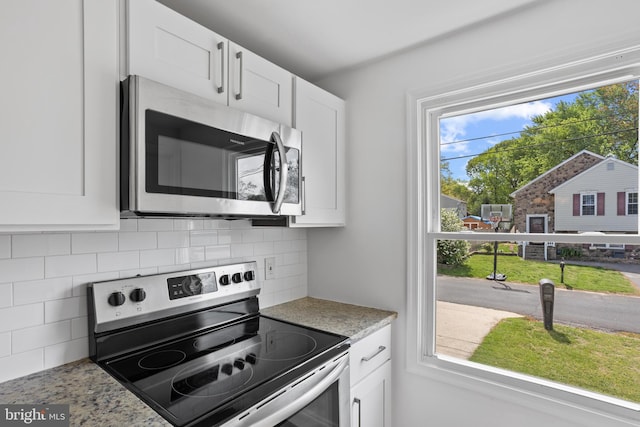 722 210th St, Pasadena, MD 21122 - kitchen with backsplash, white cabinetry, light stone countertops, and appliances with stainless steel finishes