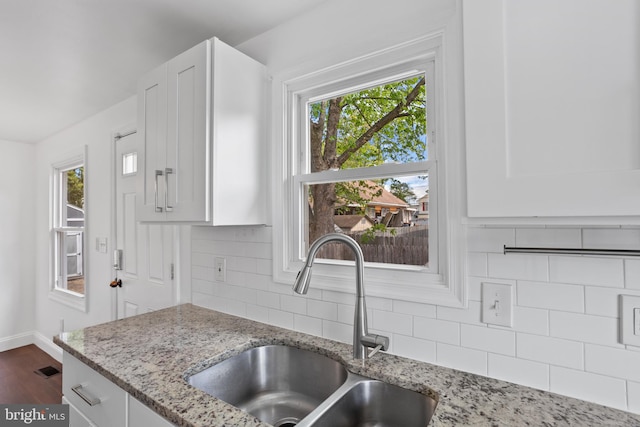722 210th St, Pasadena, MD 21122 - kitchen featuring a sink, white cabinetry, light stone countertops, and tasteful backsplash