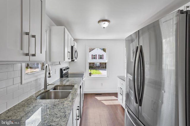 722 210th St, Pasadena, MD 21122 - kitchen featuring appliances with stainless steel finishes, a sink, white cabinetry, decorative backsplash, and dark wood-style floors